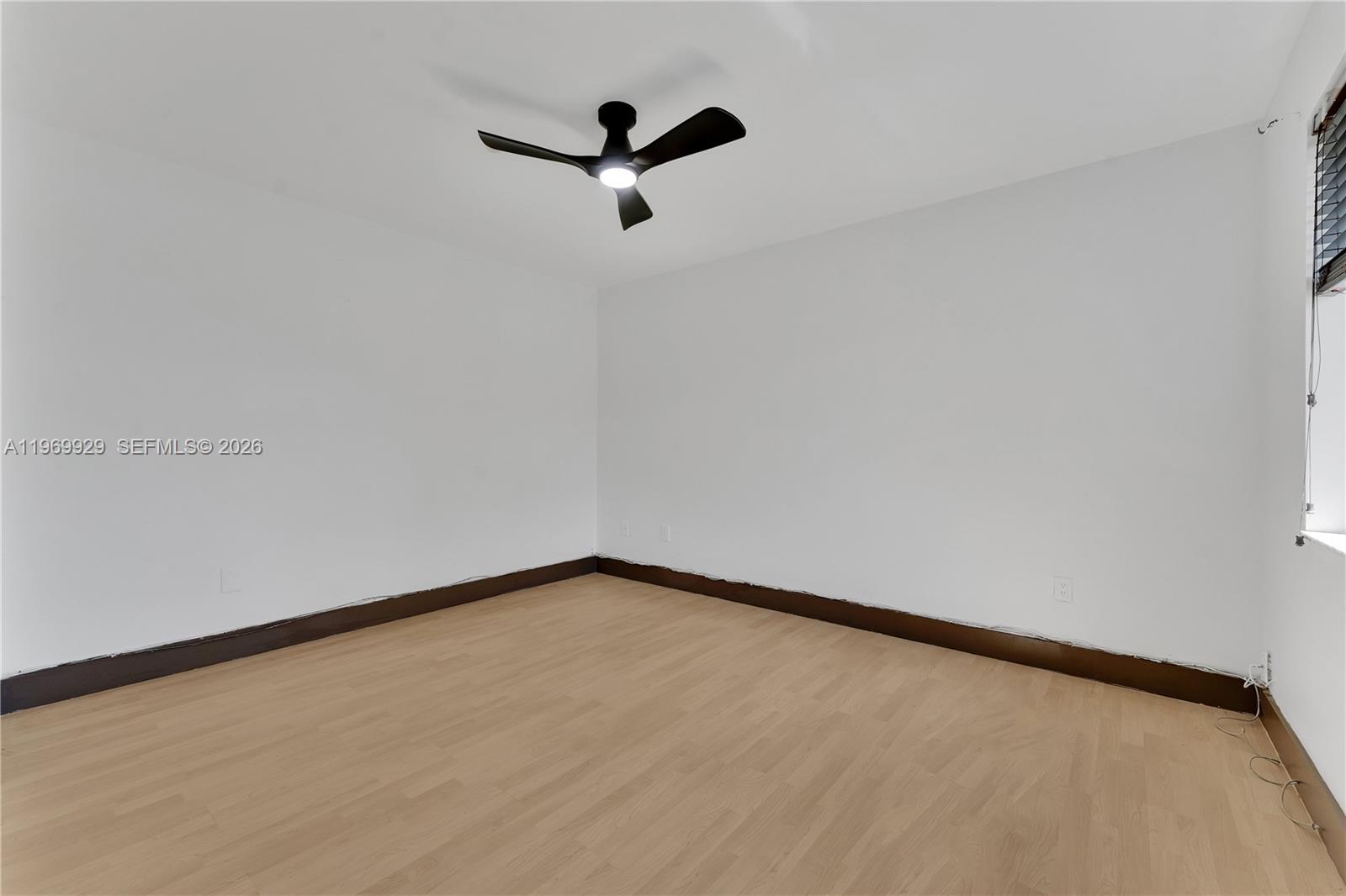 9646 Southwest 151st Avenue, Unit 1 Miami, FL 33196 - Photo 16 of 26 a view of a room with a ceiling fan and wooden floor
