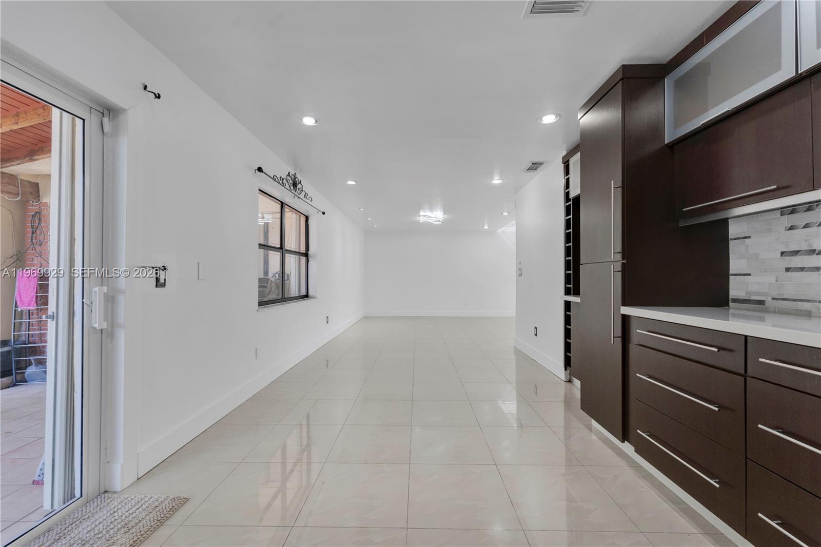 9646 Southwest 151st Avenue, Unit 1 Miami, FL 33196 - Photo 10 of 26 a view of hallway with stainless steel appliances granite countertop cabinets and empty room