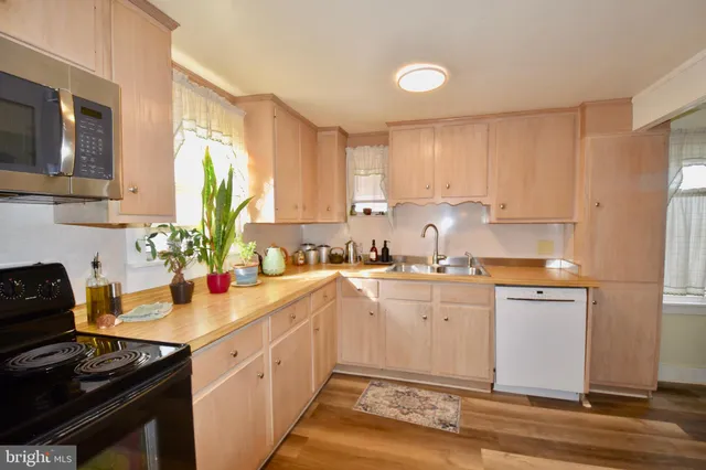 a kitchen with a sink cabinets stainless steel appliances and a window