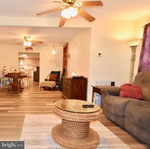 a living room with furniture a chandelier and a dining table