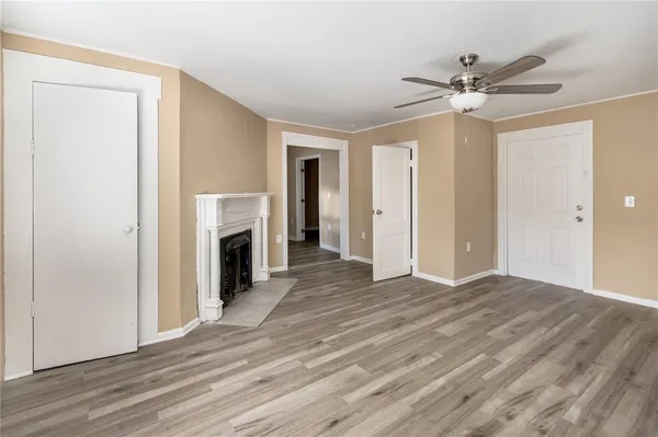 a view of a livingroom with a fireplace a ceiling fan and hardwood floor