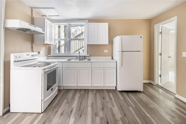 a kitchen with a stove a sink and a refrigerator