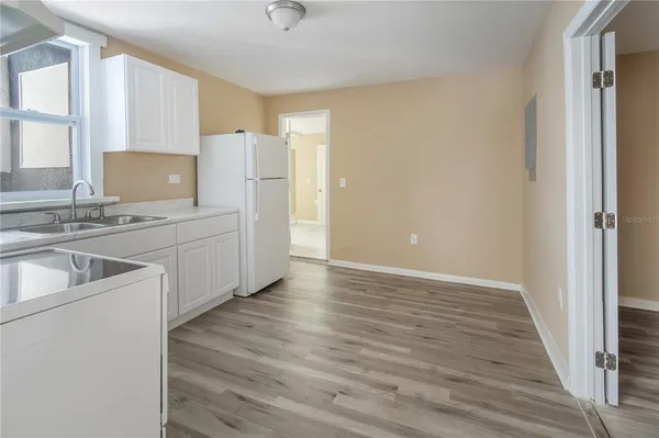 a kitchen with a sink cabinets stainless steel appliances and a window
