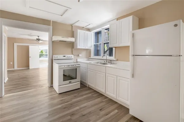 a kitchen with white cabinets and white appliances