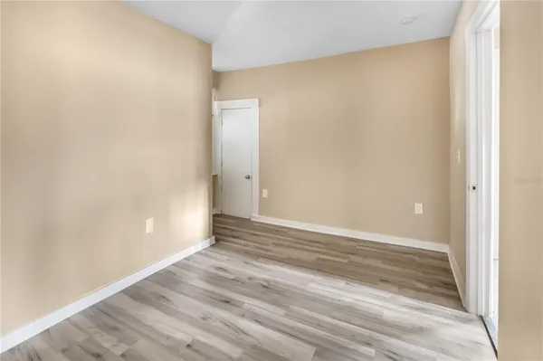 a view of an empty room with wooden floor