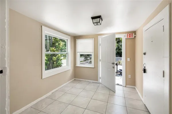 a view of an empty room with closet and a window