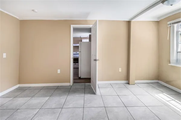 a view of an empty room with window and a bathroom