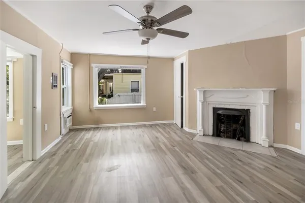 a view of an empty room with a fireplace and a window