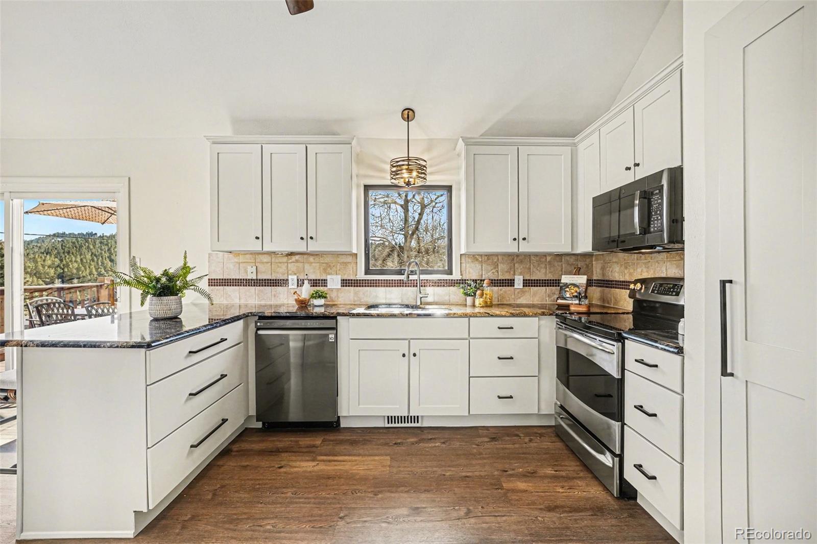 3260 Bit Road Evergreen, CO 80439 - Photo 5 of 26 a kitchen with white cabinets and appliances