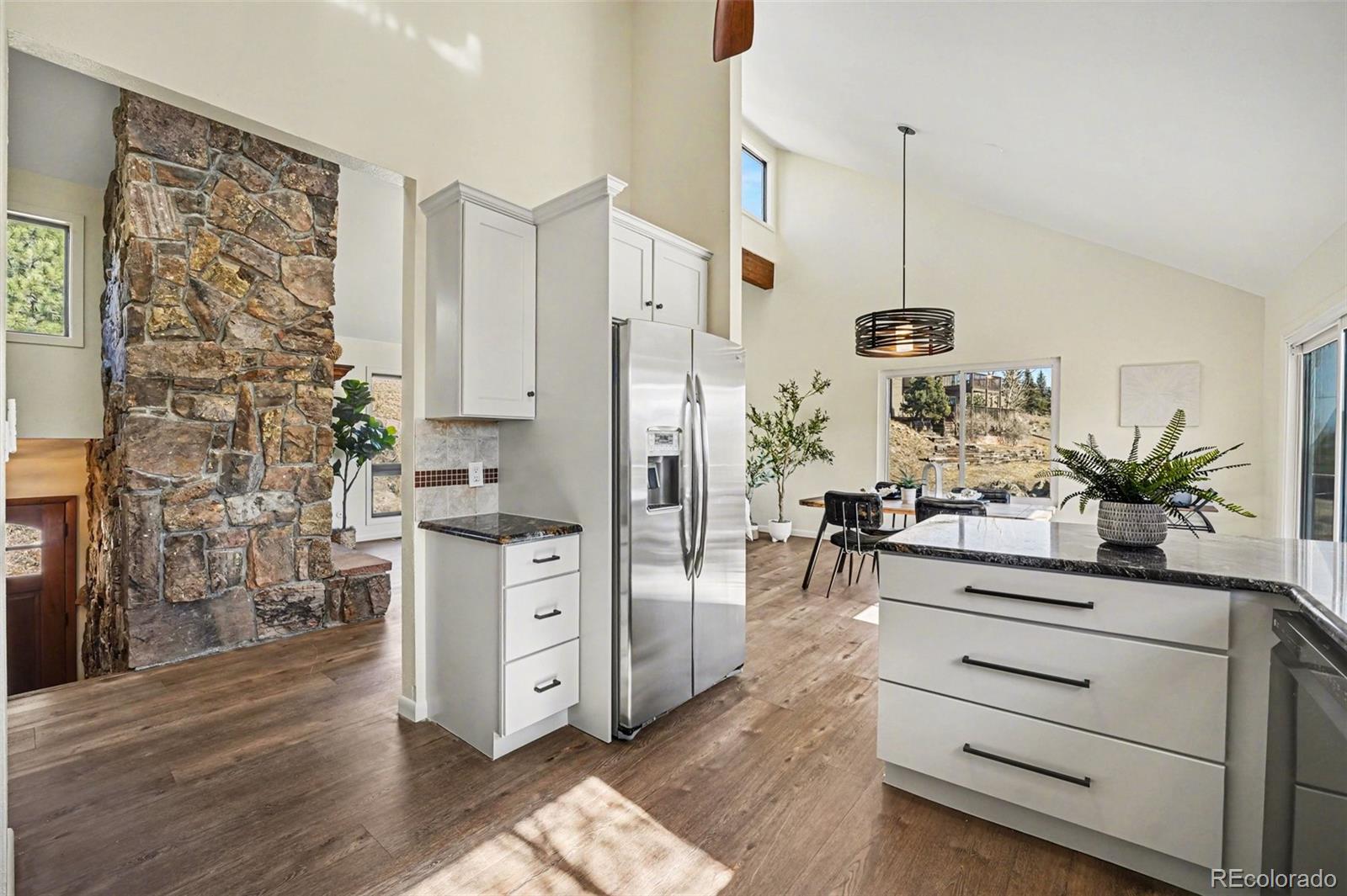 3260 Bit Road Evergreen, CO 80439 - Photo 6 of 26 a living room with stainless steel appliances kitchen island granite countertop furniture and a living room
