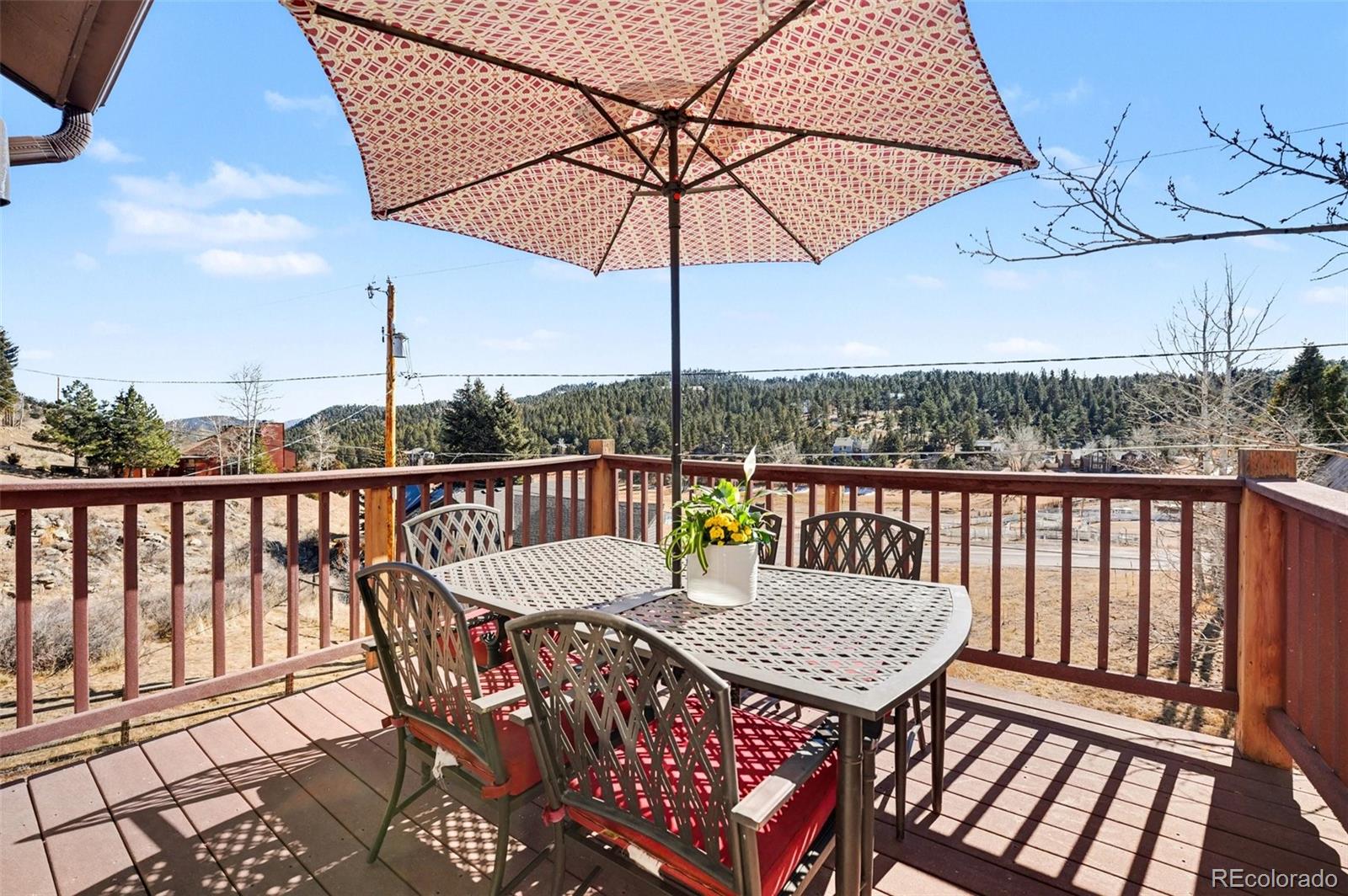 3260 Bit Road Evergreen, CO 80439 - Photo 8 of 26 a view of a balcony with wooden floor and outdoor seating
