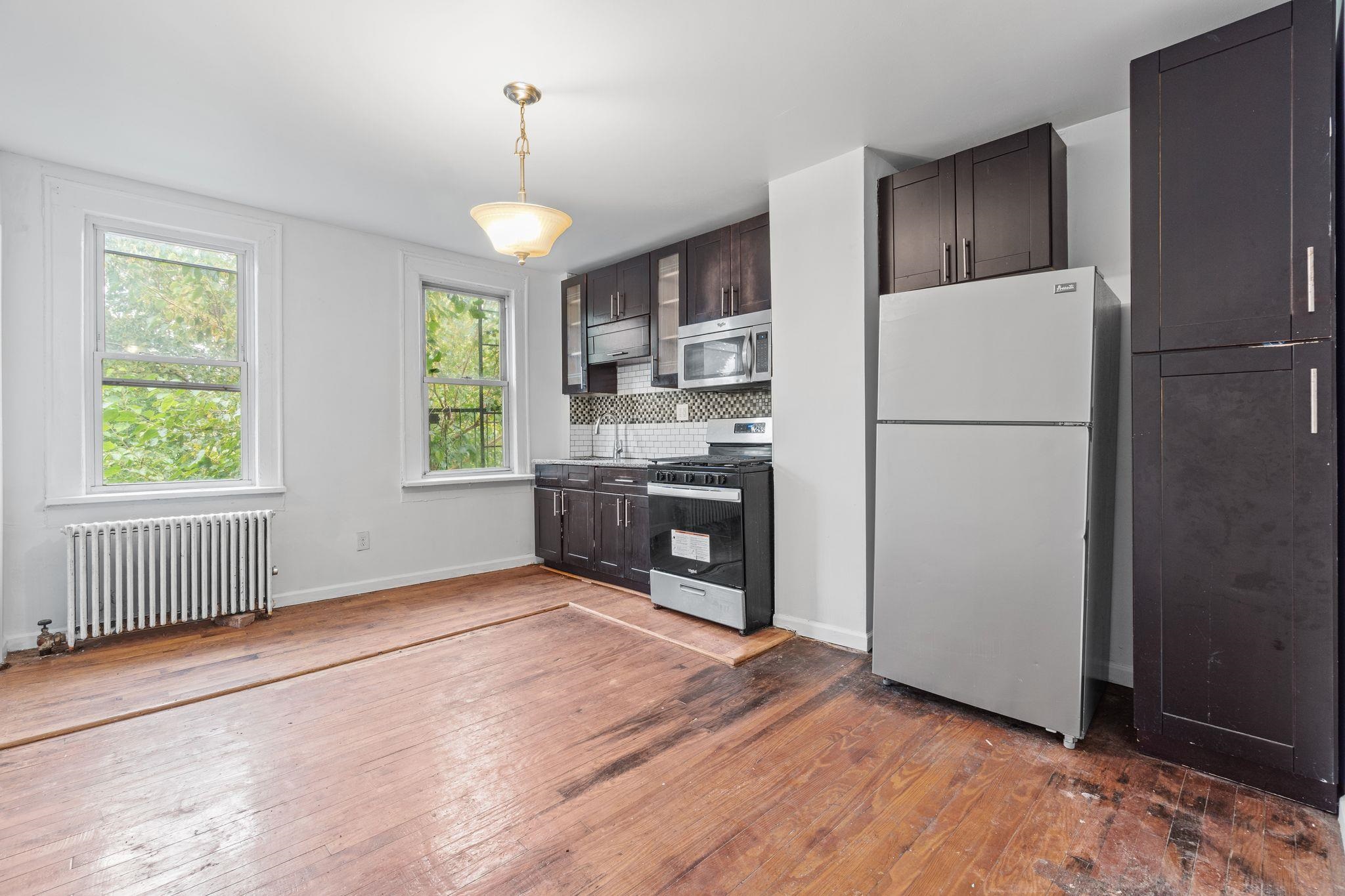 91 Ocean Avenue, Unit 3 Jersey City, NJ 07305 - Photo 1 of 14 a kitchen with stainless steel appliances granite countertop a refrigerator a stove a sink dishwasher and a refrigerator with wooden floor