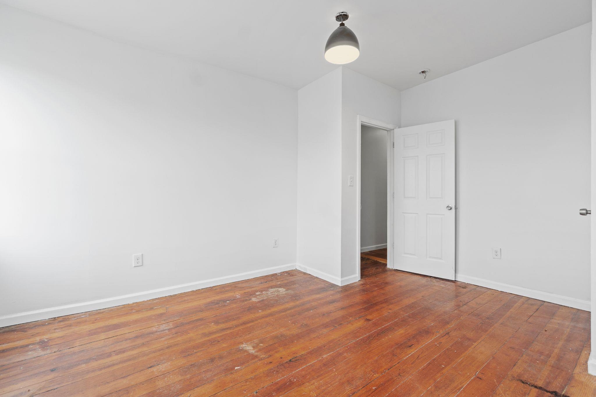 91 Ocean Avenue, Unit 3 Jersey City, NJ 07305 - Photo 3 of 14 an empty room with wooden floor and windows