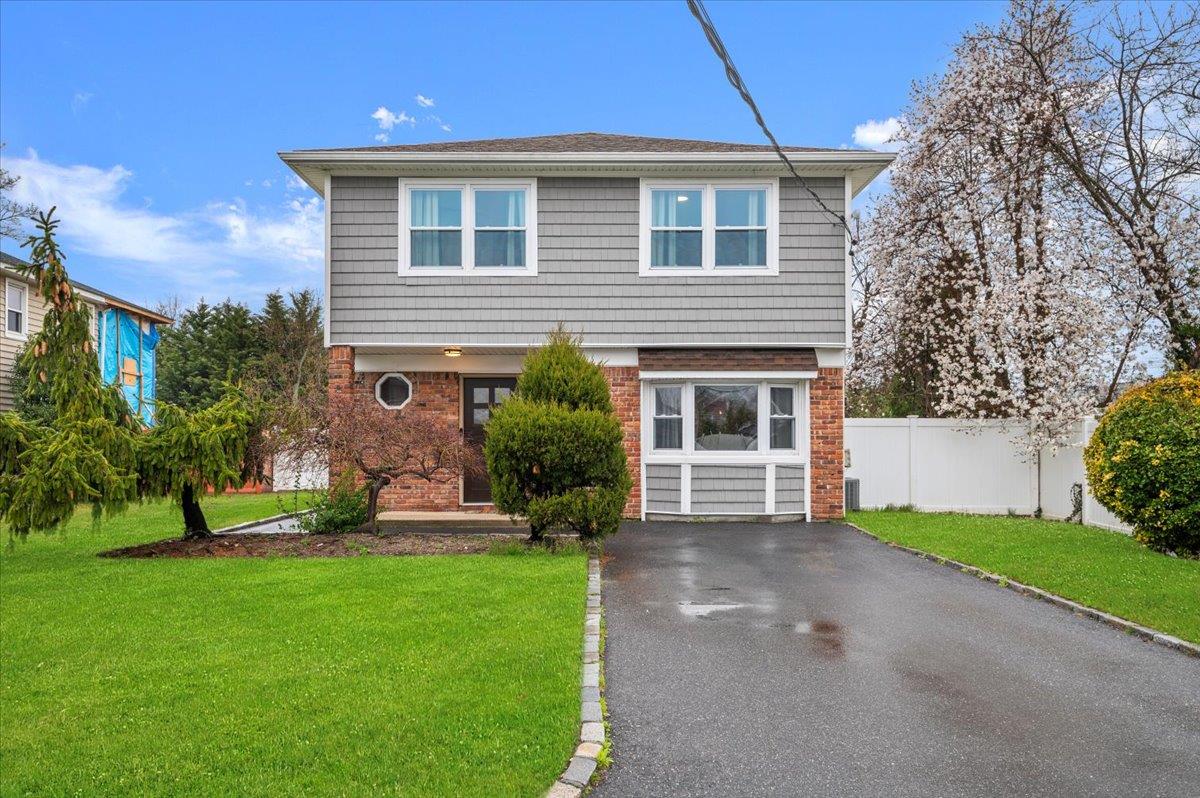 a front view of a house with a yard and trees