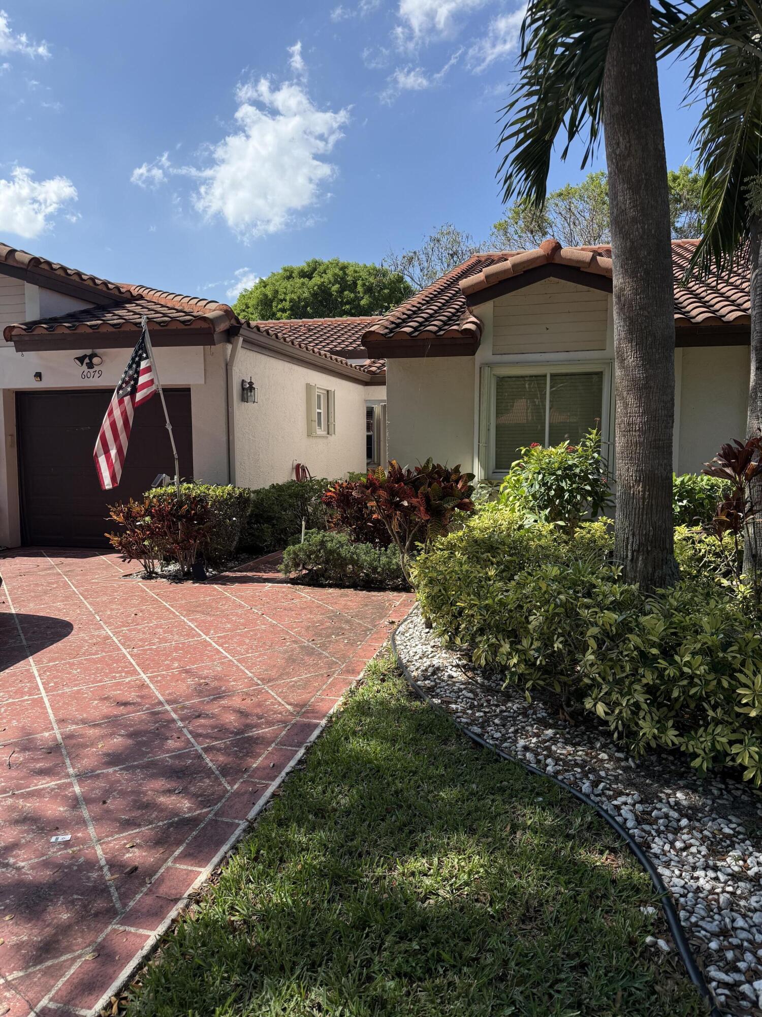6079 Millington Way Delray Beach, FL 33484 - Photo 2 of 38 a front view of a house with a yard and garage