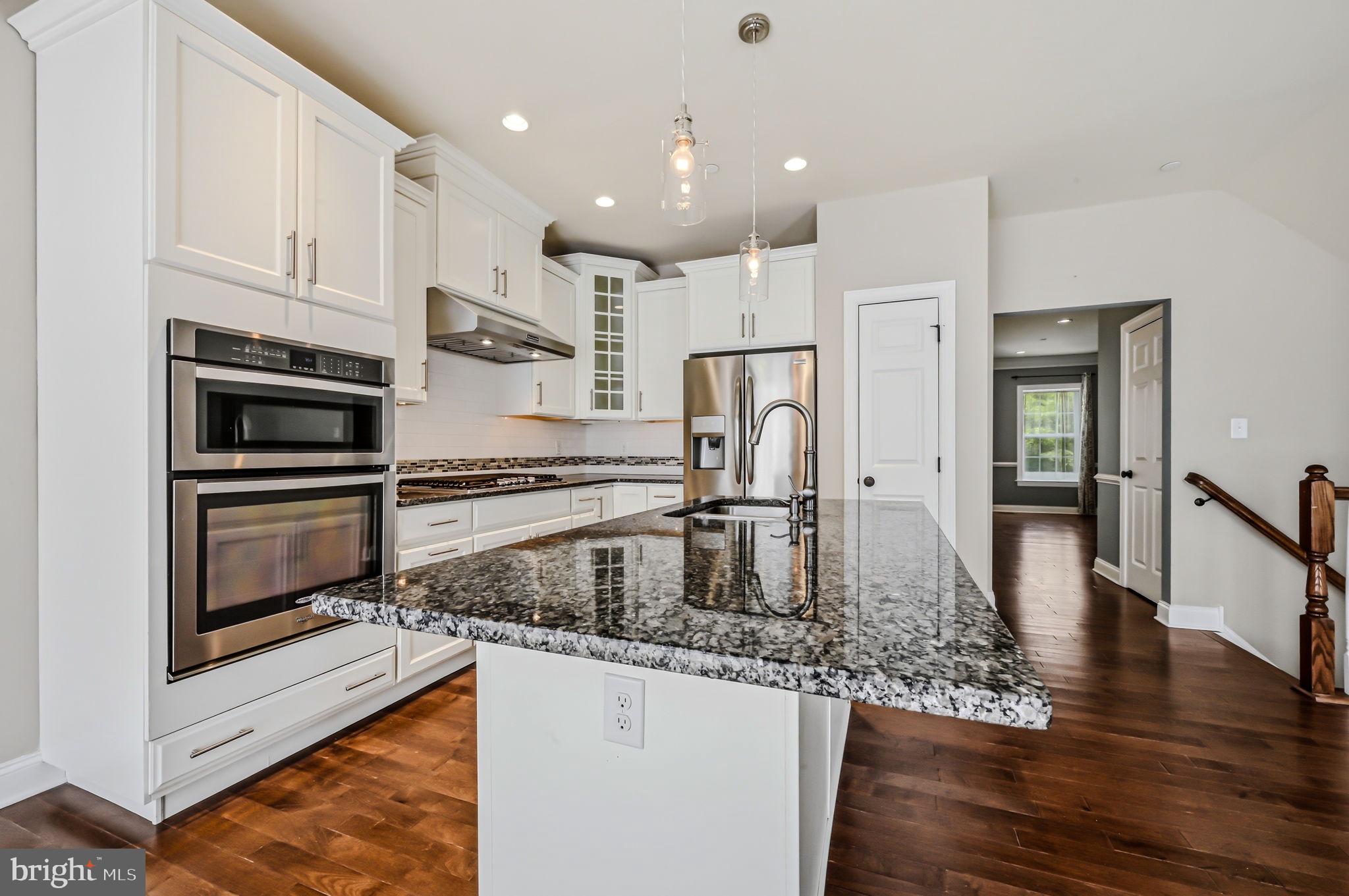 208 Jackdaw Alley, Unit 208 Springfield, PA 19064 - Photo 13 of 49 a kitchen with kitchen island granite countertop a refrigerator oven a sink and white cabinets