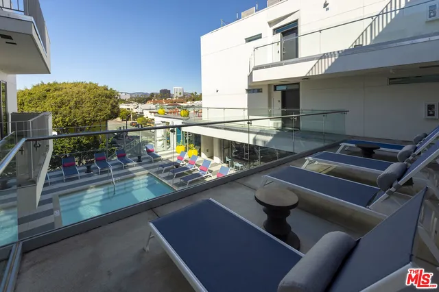 a view of roof deck with dining table and chairs