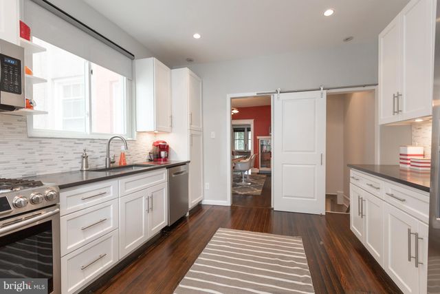 a kitchen with granite countertop a refrigerator and sink