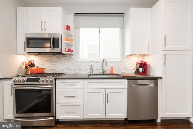 a kitchen with white cabinets and appliances