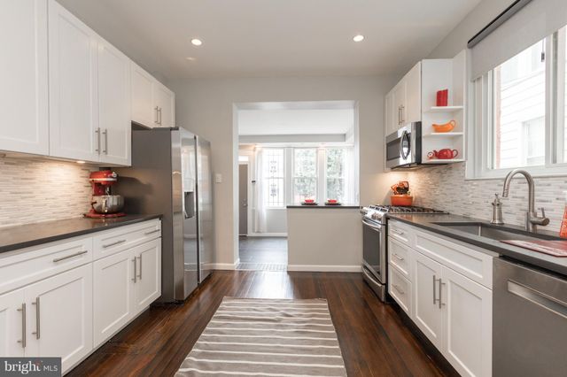 a kitchen with stainless steel appliances a refrigerator sink and white cabinets