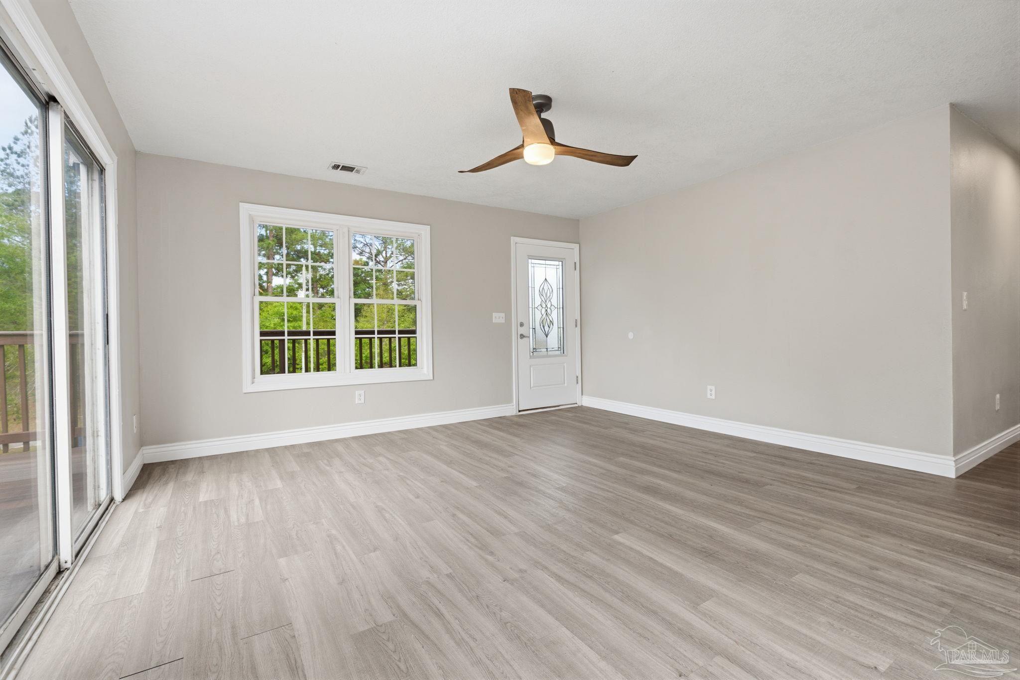 4032 Mae Lane Milton, FL 32583 - Photo 16 of 50 a view of an empty room with wooden floor and a window