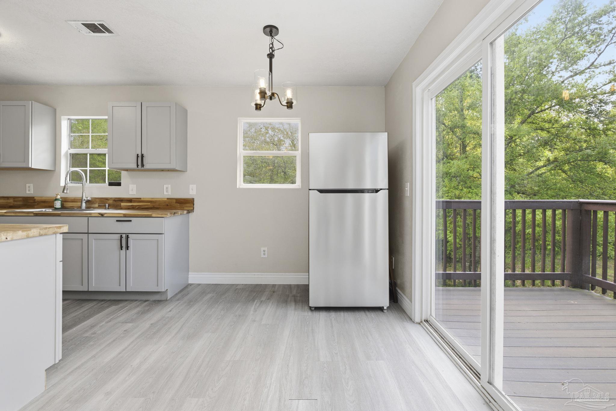 4032 Mae Lane Milton, FL 32583 - Photo 21 of 50 a kitchen with a refrigerator a sink and cabinets