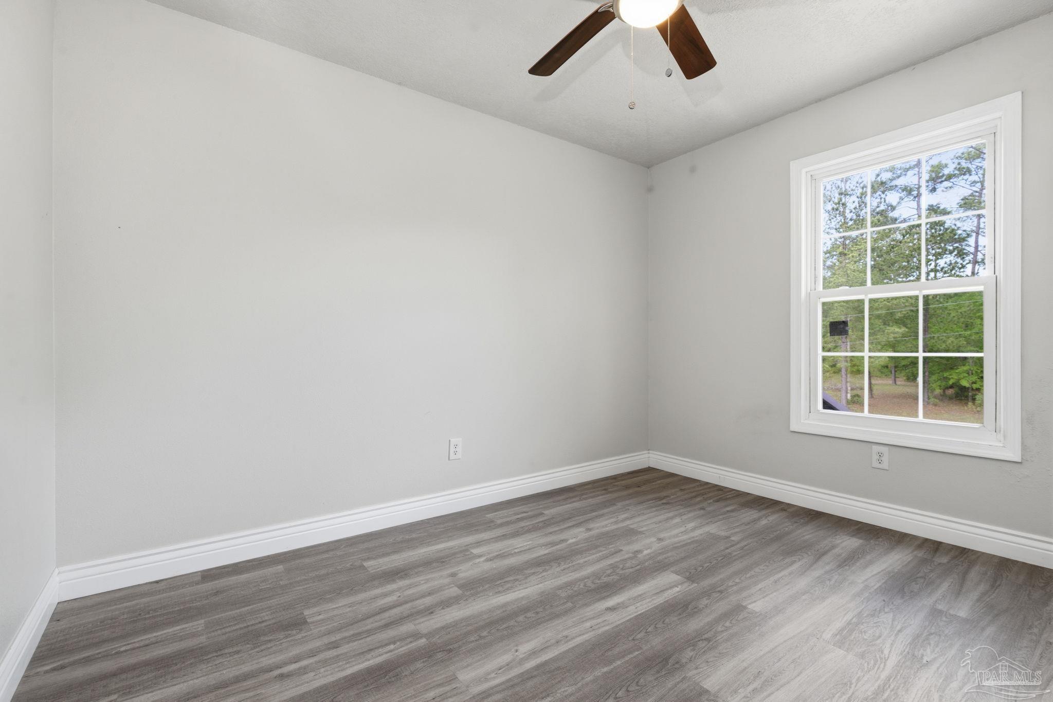 4032 Mae Lane Milton, FL 32583 - Photo 23 of 50 an empty room with a window and wooden floor
