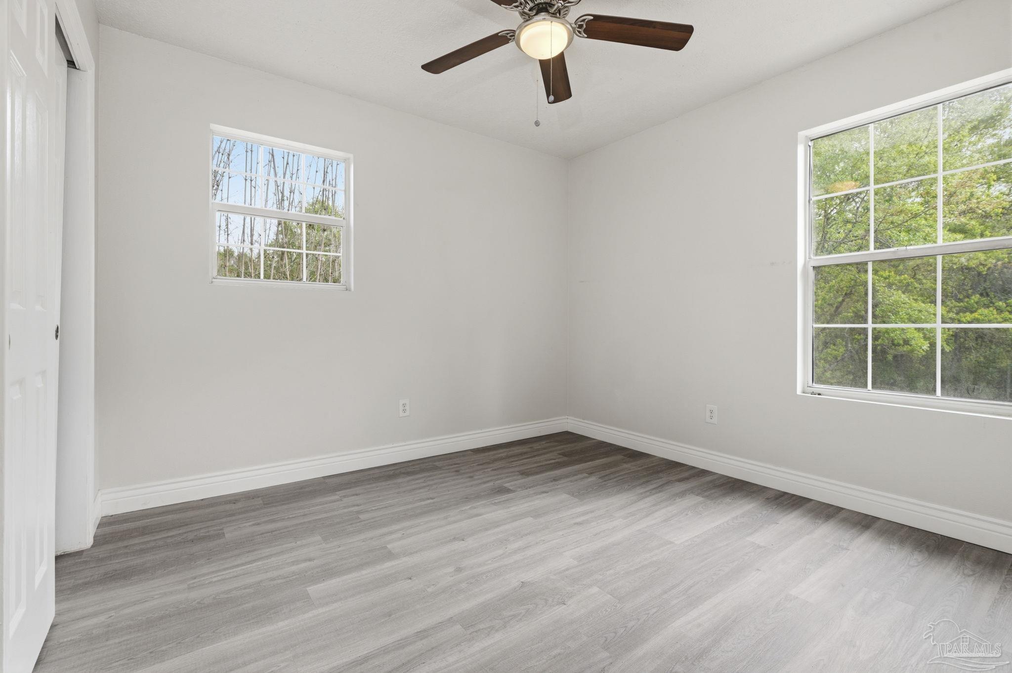4032 Mae Lane Milton, FL 32583 - Photo 27 of 50 a view of an empty room with a window and wooden floor