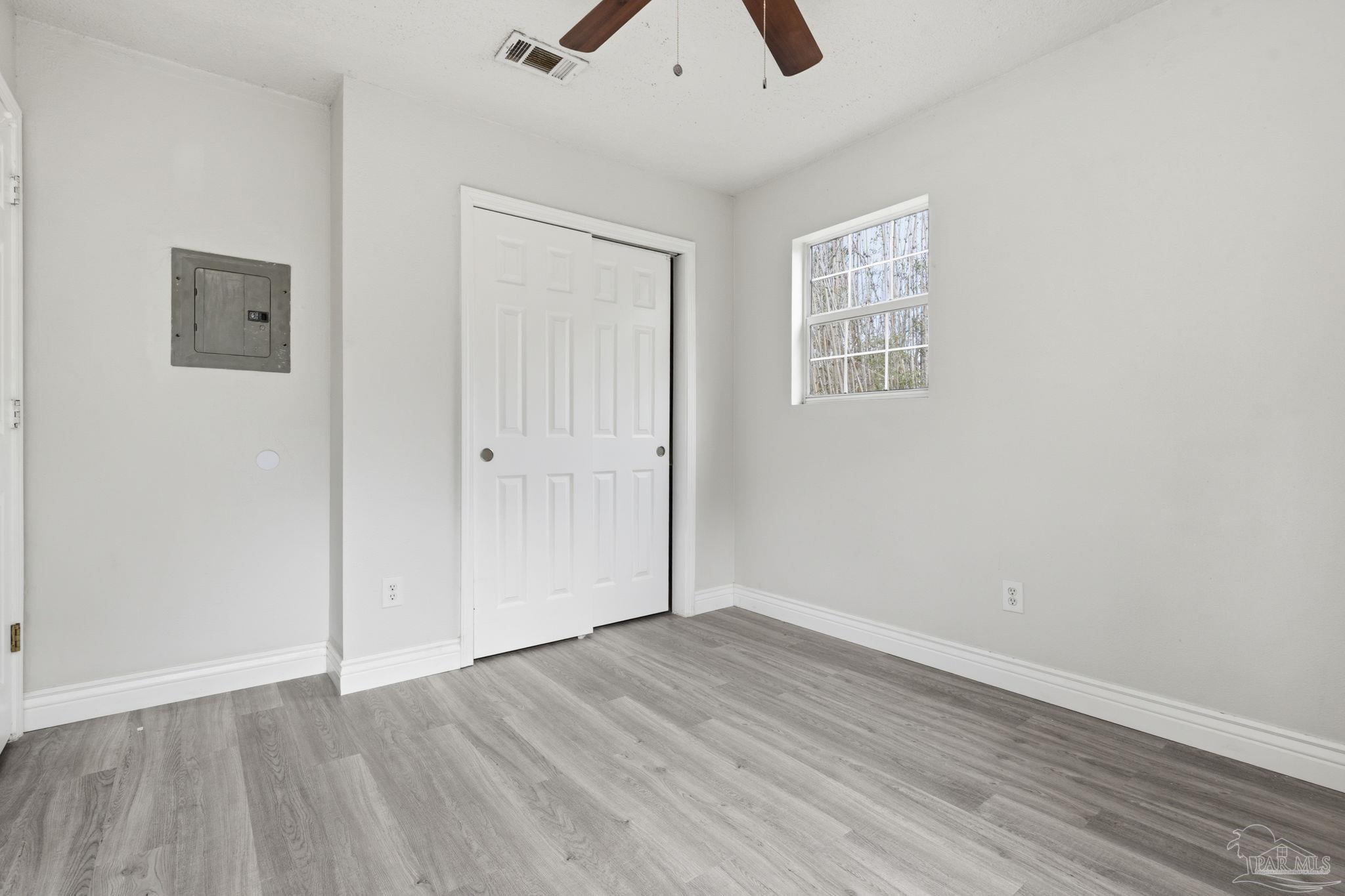 4032 Mae Lane Milton, FL 32583 - Photo 28 of 50 an empty room with wooden floor and windows