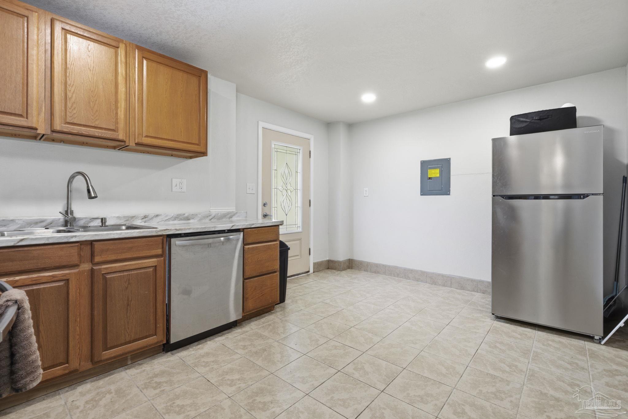 4032 Mae Lane Milton, FL 32583 - Photo 29 of 50 a kitchen with granite countertop a refrigerator a sink and white cabinets