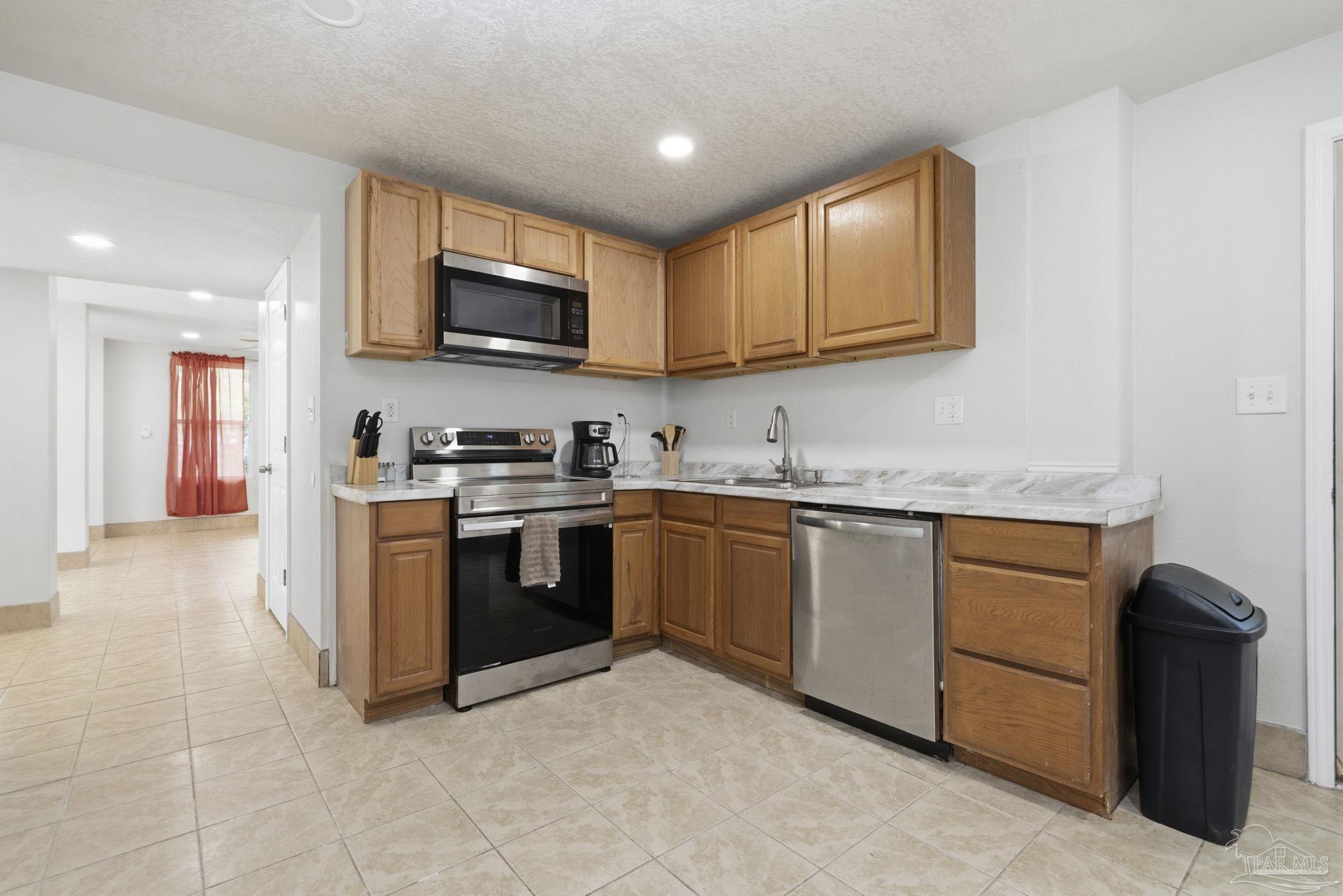 4032 Mae Lane Milton, FL 32583 - Photo 31 of 50 a kitchen with stainless steel appliances granite countertop a stove top oven a sink a refrigerator and white cabinets