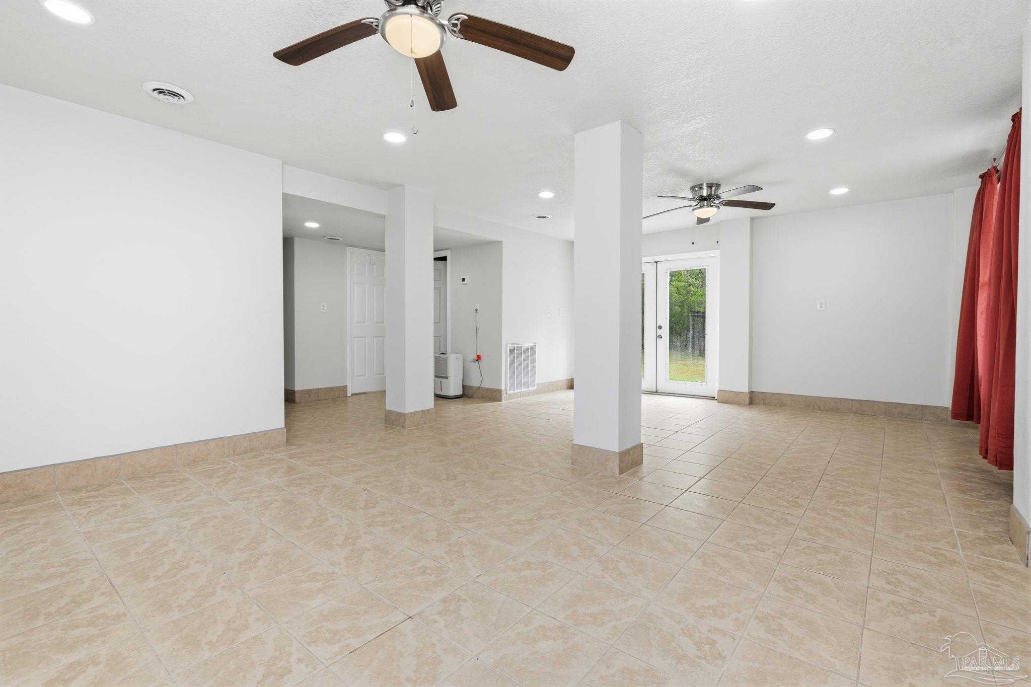 4032 Mae Lane Milton, FL 32583 - Photo 36 of 50 an empty room with chandelier fan and kitchen view