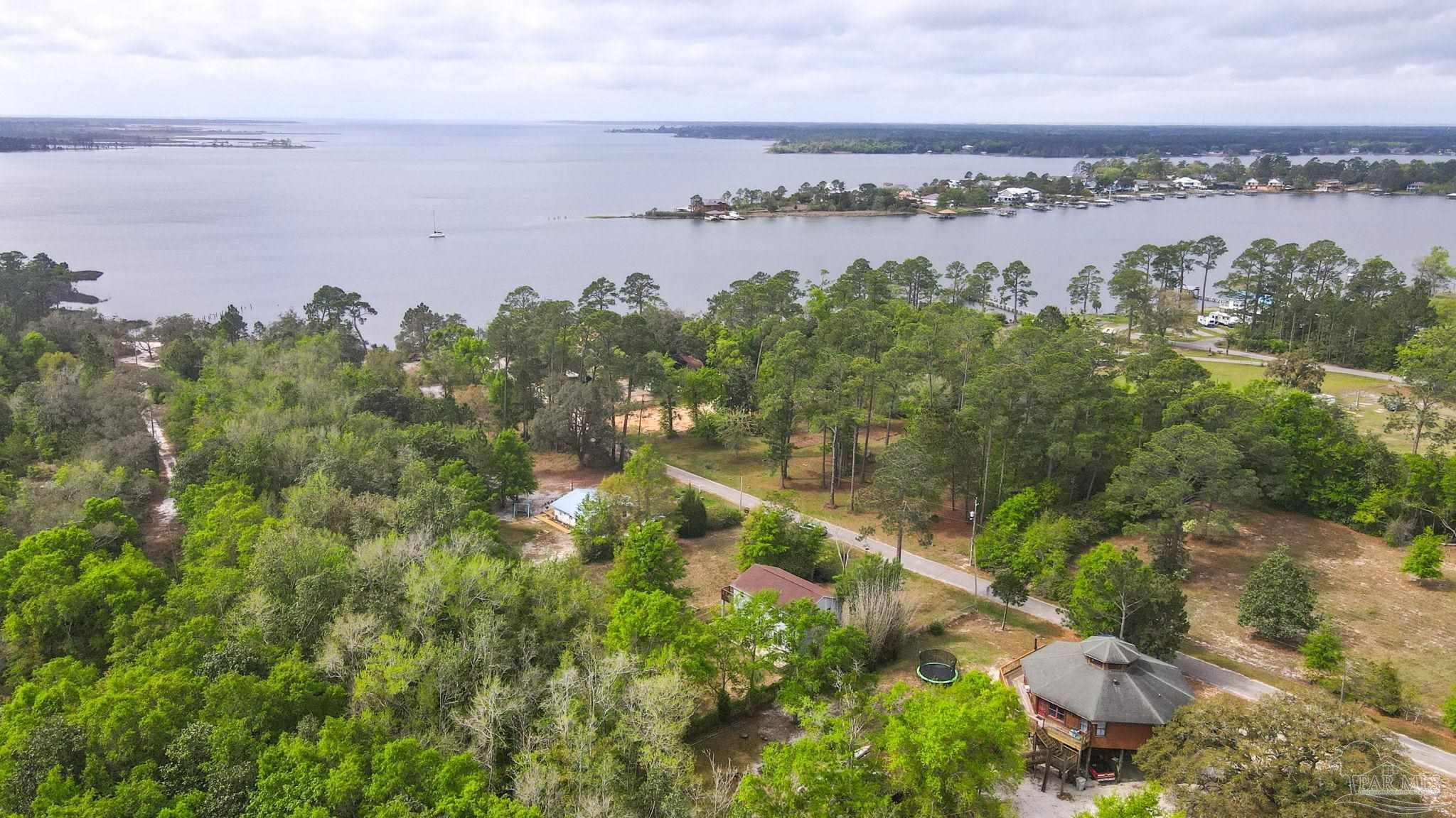 4032 Mae Lane Milton, FL 32583 - Photo 38 of 50 a view of a lake with houses in the back