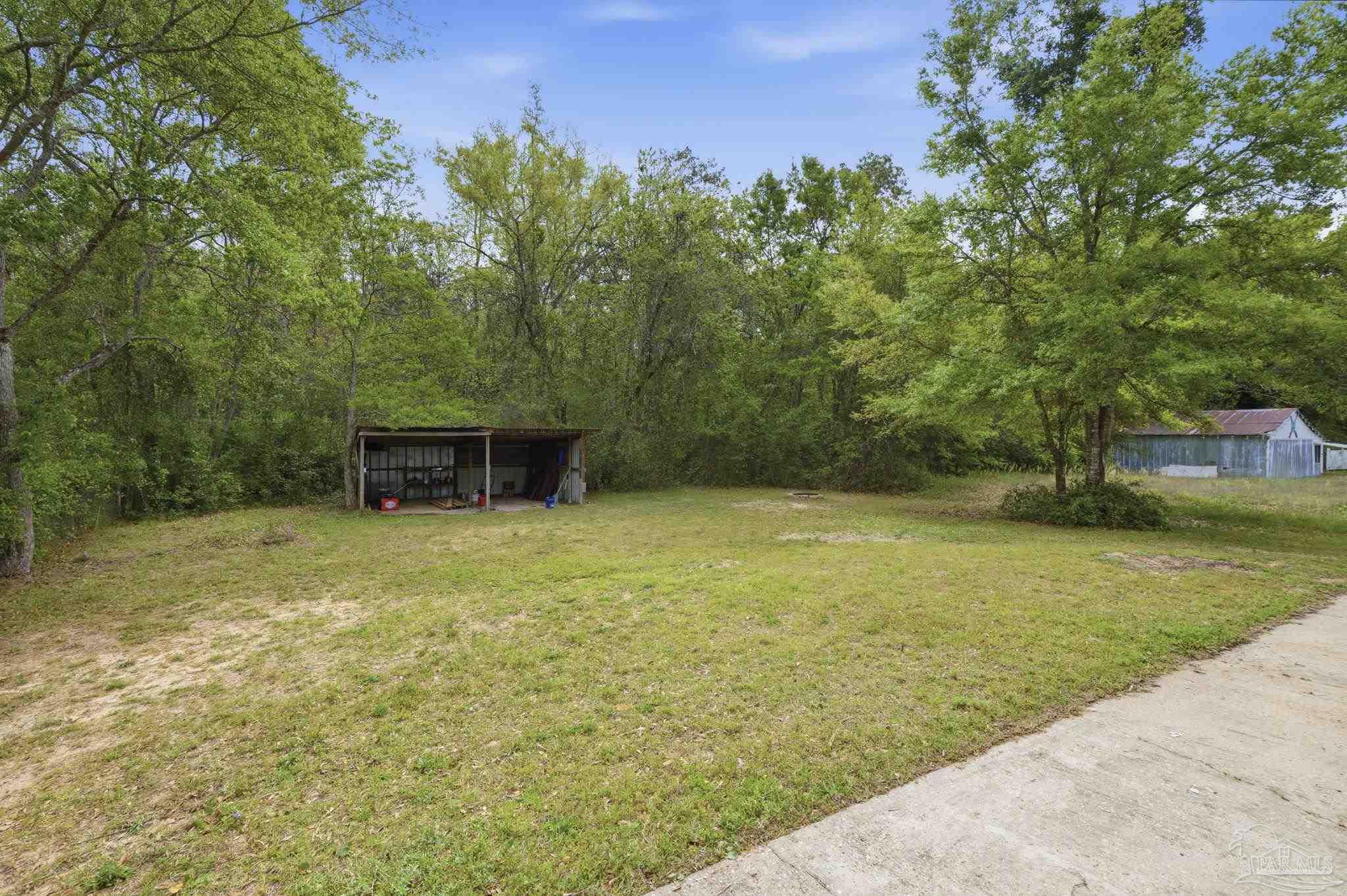 4032 Mae Lane Milton, FL 32583 - Photo 10 of 50 a backyard of a house with lots of green space