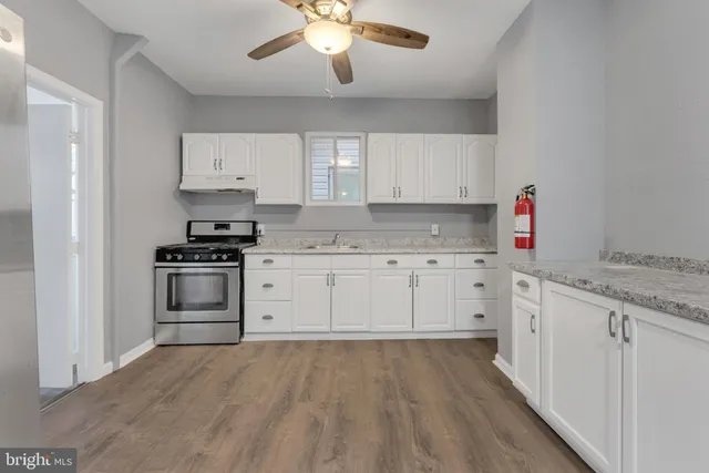 a kitchen with granite countertop a sink stainless steel appliances and cabinets