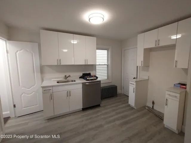 a kitchen with a sink a refrigerator and cabinets