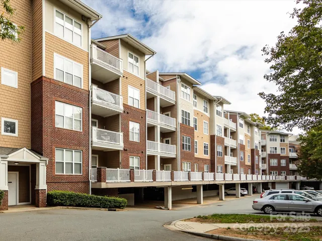 a front view of a building with street view and trees