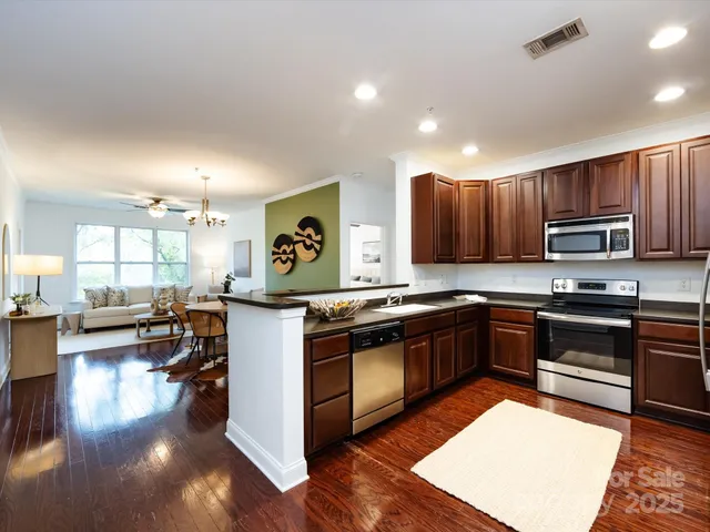 a kitchen with a sink appliances and wooden floor