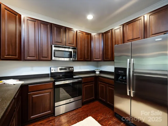 a kitchen with wooden cabinets and stainless steel appliances