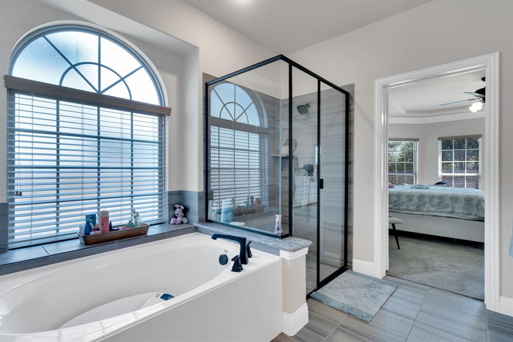129 Micco Lane Fate, TX 75087 - Photo 13 of 31 a bathroom with a tub a window and a shower