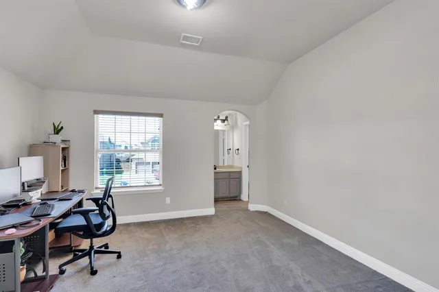 a view of a workspace with furniture and a window