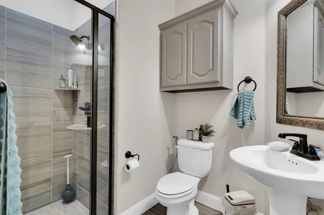 a bathroom with a toilet a sink and shower