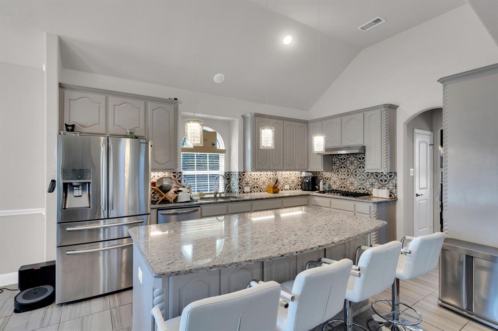 129 Micco Lane Fate, TX 75087 - Photo 4 of 31 a kitchen with stainless steel appliances granite countertop a refrigerator and a stove