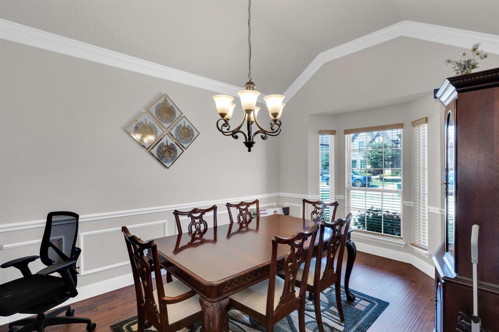 129 Micco Lane Fate, TX 75087 - Photo 8 of 31 a view of a dining room with furniture a chandelier and wooden floor