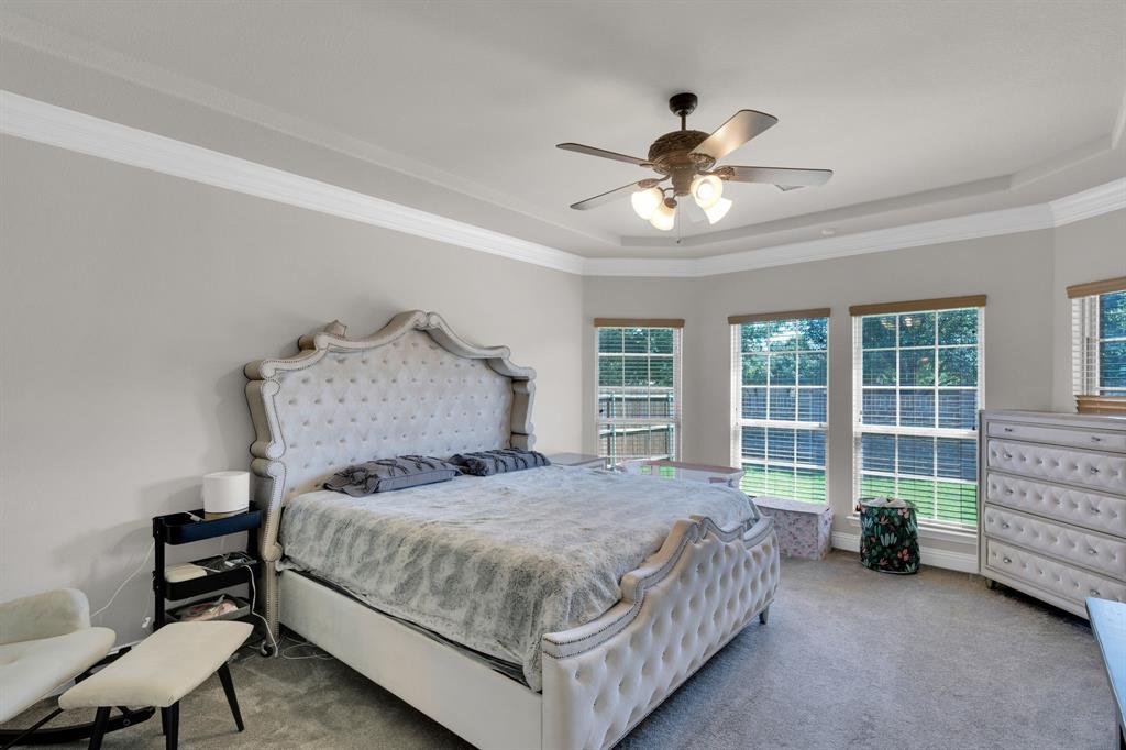 129 Micco Lane Fate, TX 75087 - Photo 10 of 31 a bedroom with a bed and a chandelier