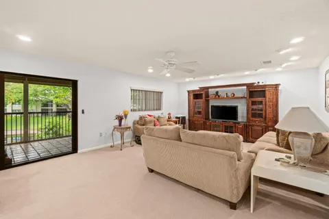 a living room with furniture floor to ceiling window and a flat screen tv
