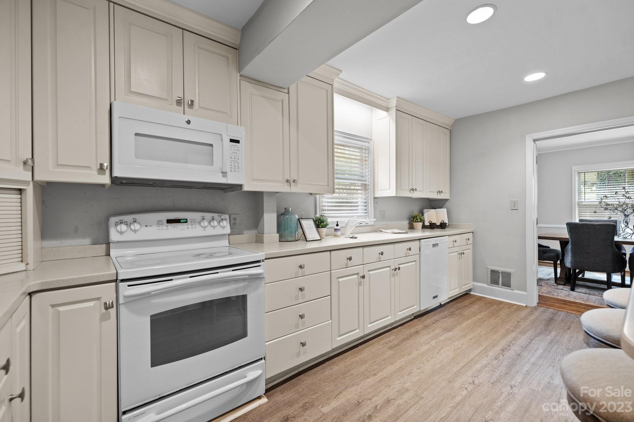 312 Brandywine Road Charlotte, NC 28209 - Photo 11 of 31 a kitchen with granite countertop white cabinets and white appliances