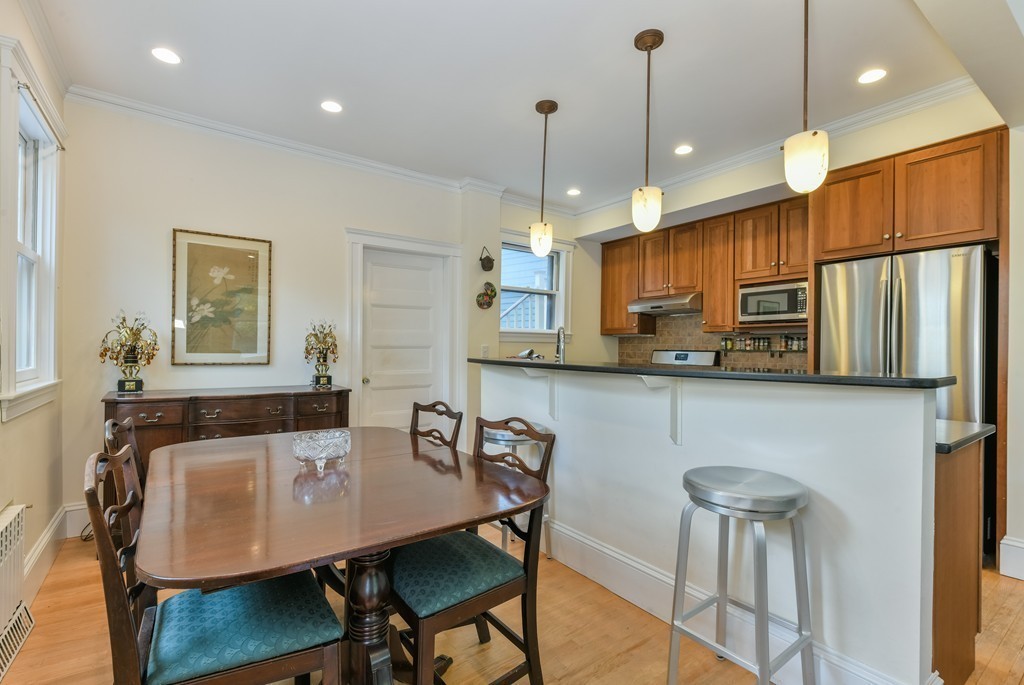 78 Windsor Road, Unit 1 Brookline, MA 02445 - Photo 5 of 11 a kitchen with stainless steel appliances granite countertop a kitchen island a table and chairs
