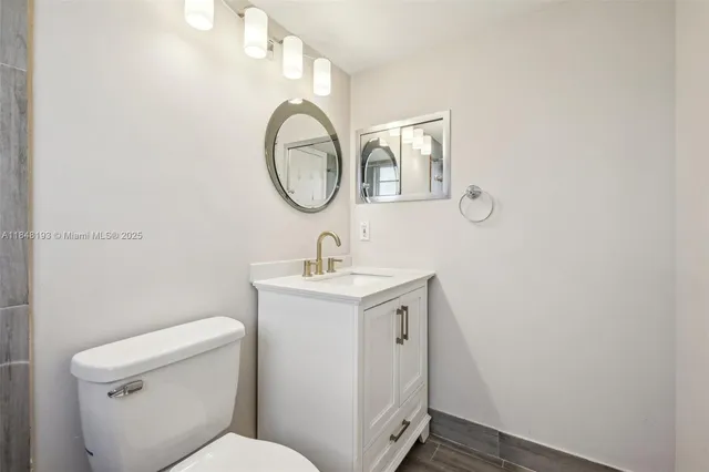 a bathroom with a sink a toilet and a mirror