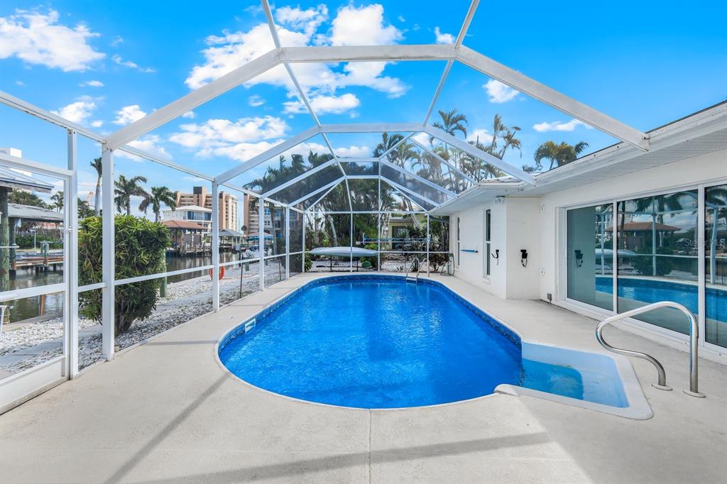 8552 Lagoon Road Fort Myers Beach, FL 33931 - Photo 19 of 33 a view of a swimming pool with a patio and a yard